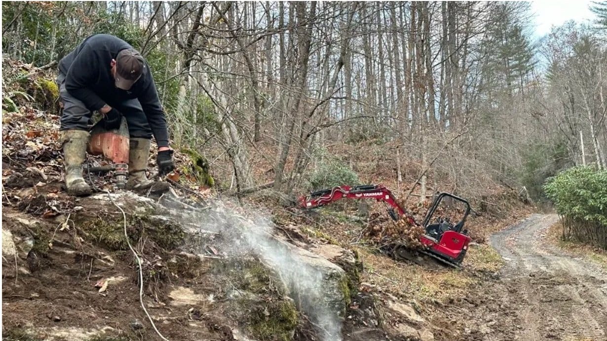 Splitting rock on a hillside above a mountain access road